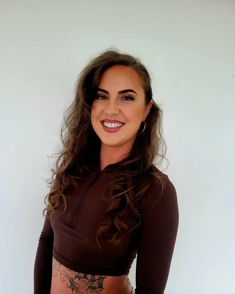 Jayne, Latin Heels teacher at Femme and Soul, smiling in a studio portrait