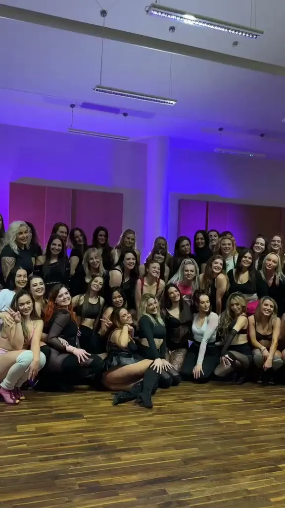 The group celebrating under purple light after a showcase