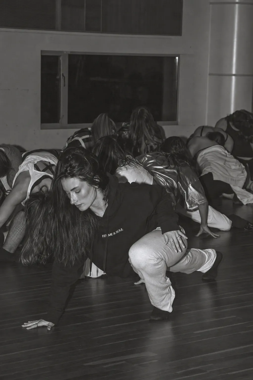 Floorwork in a hoodie, arms tracing a slow line