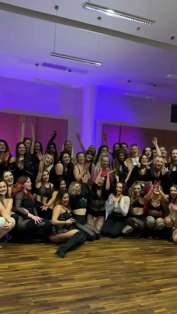 Femme & Soul women celebrating together with their arms raised in warm purple studio light
